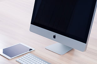 silver iMac, white iPad, and Apple Keyboard on table
