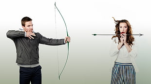 man holding bow and woman holding arrow photo