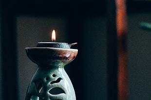 selective focus photography of green ceramic oil candle diffuser