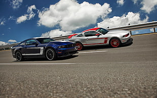 two silver and blue Ford Mustang GT Boss 302 coupes, car