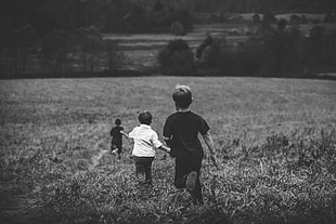 grayscale photography of children playing on field