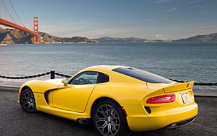 yellow convertible car in front of body of water