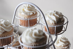 brown cupcake with white cream on white steel rack