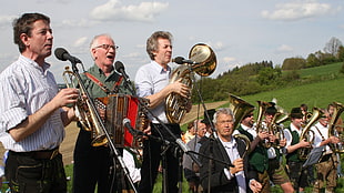 group of man playing wind instrument during daytime
