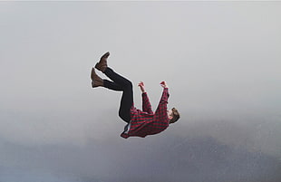 man in red and black checked dress shirt and black pants falling in the sky during daytime HD wallpaper