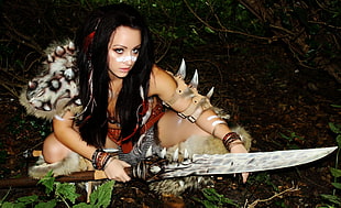 woman holding animal tooth sword