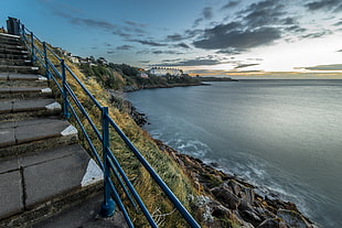 gray stairs pavement with black metal railings near sea, sorrento, killiney, dublin, ireland