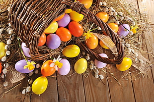 assorted-color Easter egg lot and brown wicker basket
