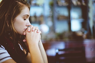 woman wearing black and white stripes shirt praying photo