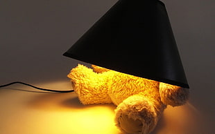 bear plush toy base and black cone shade table lamp turned on