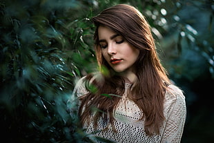 woman in gray mesh shirt standing near green leaf tree