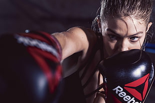 woman wearing black-and-red Reebok boxing gloves