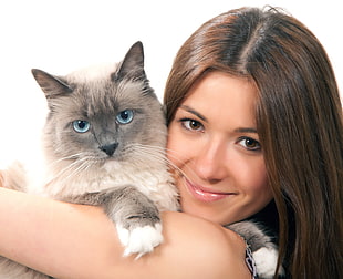 woman hugging Siamese cat
