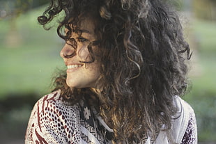 photo of woman in white and brown shirt with curly hair