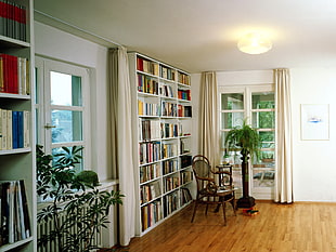 white wooden bookshelf near window