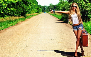 woman signaling to take a hitch at road during daytime HD wallpaper