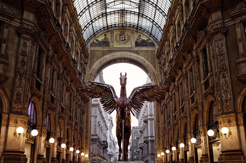 brown winged statue under architectural building HD wallpaper