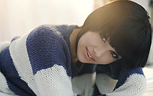 black-haired woman with bangs in blue and white stripe knitted sweater