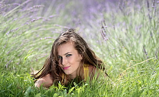 photography of woman laying on green grass