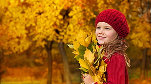 girl in red sweater holding yellow leaves HD wallpaper