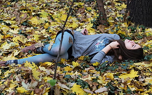 woman laying on dried leaf