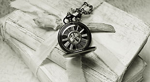 round black analog pocket watch on white wooden box