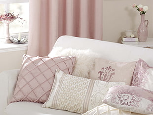 white and pink couch with throw pillows