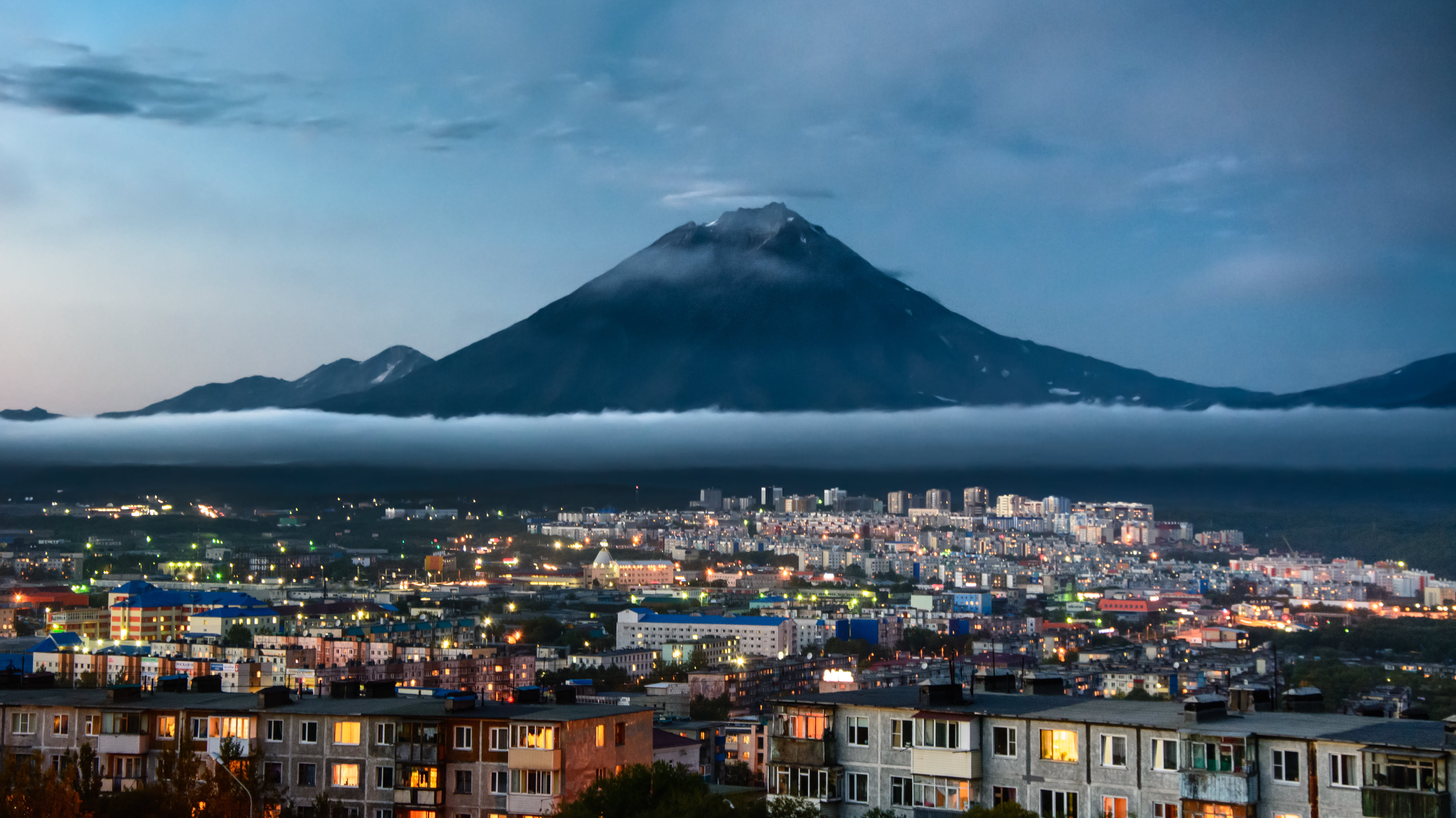 mountain across city under cloudy sky during dusk, kamchatka