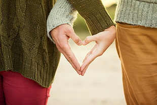 two person combining there hands to make  heart shape
