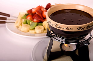 brown and beige chocolate fondue with assorted fruits