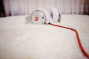 white Beats headphones on white textile