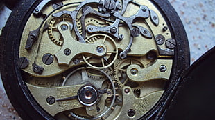 round gold-colored skeleton watch, clockwork