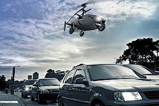 helicopter above cars under cloudy sky