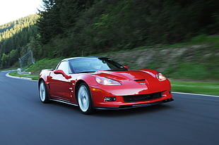 red sports car travelling during daytime HD wallpaper