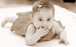 baby in sleeveless dress leaning in white blanket HD wallpaper