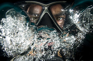 man wearing diving glasses under water