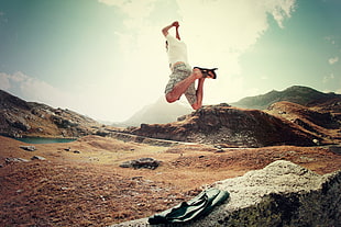man in white shirt jumping near lake painting HD wallpaper