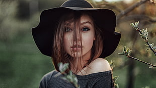 tilt shift lens photography of woman wearing black hat and scoop-neck top