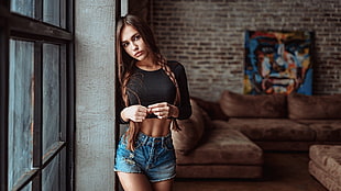woman in crop top leaning on wall