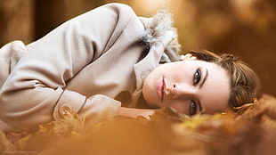 woman wearing gray coat lying on ground HD wallpaper