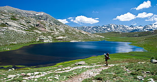 panorama photography of man standing near clear lake and mountain range view, lac HD wallpaper