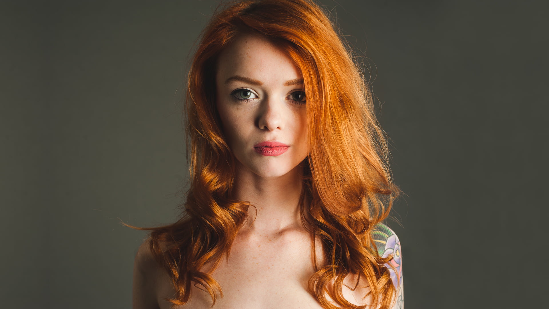 woman with red hair with shoulder tattoo