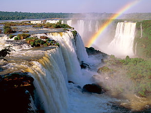 photograph of waterfalls with rainbow