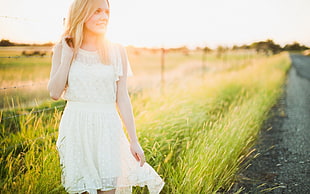 woman in white dress on green grass field at daytime