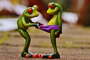 two green frogs ceramic toy in close-up photography HD wallpaper