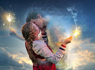 man and woman kissing and holding fireworks
