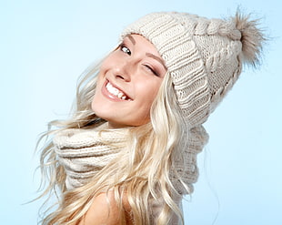winking woman wearing white knitted cap