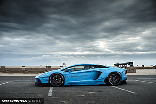 blue supercar on road under cloudy sky