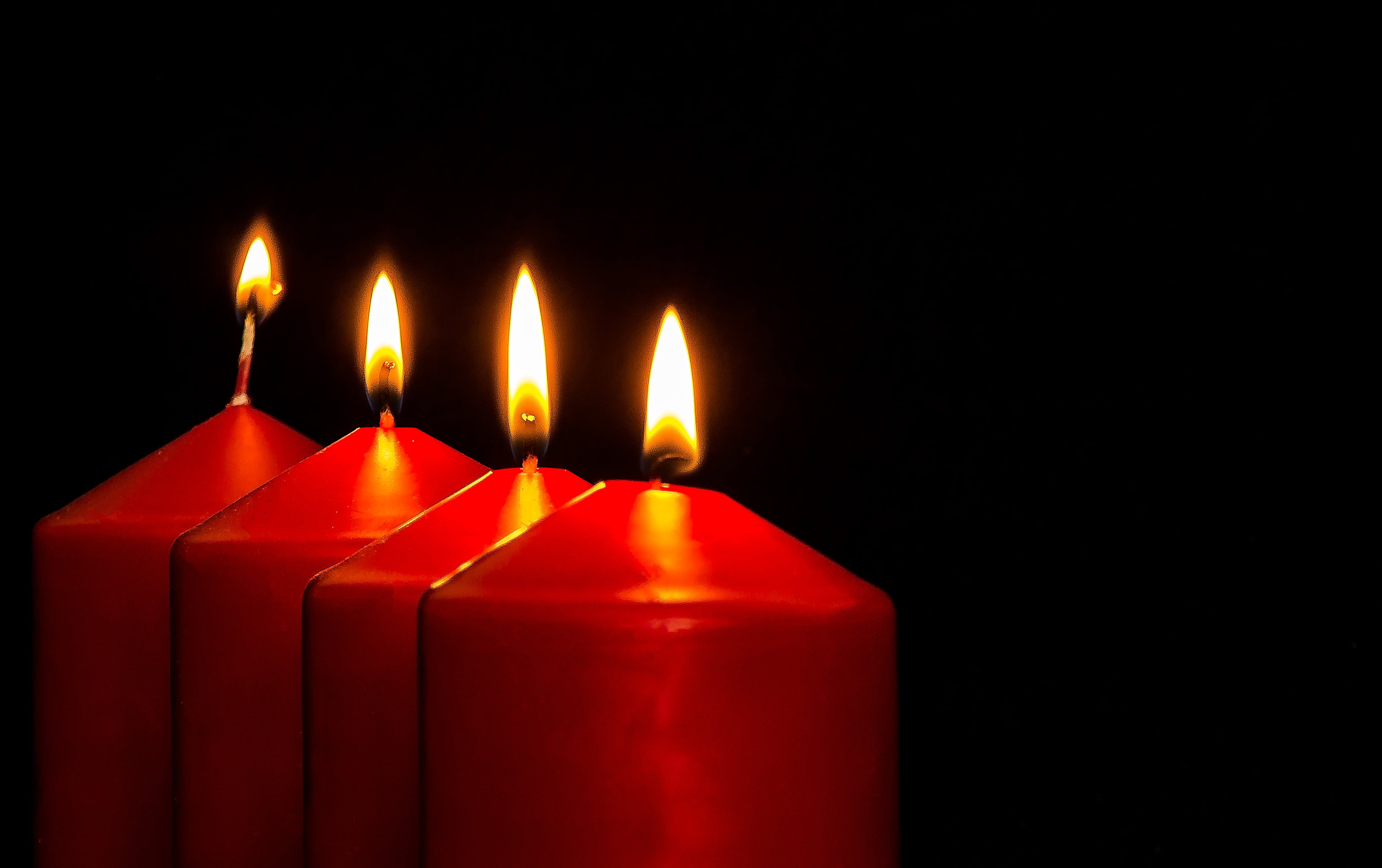 time lapse photography of four red pillar candles