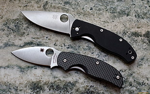 closeup photo of two black pocket knives